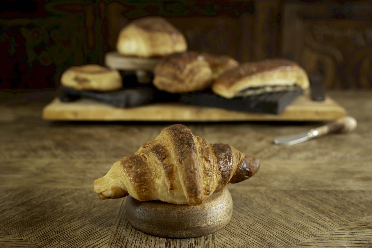 A croissant placed on a wooden stump/https://sareden.com/products/croissant